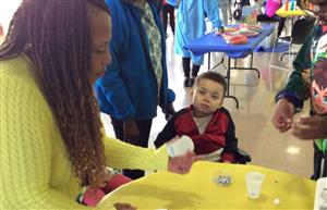 Teacher helping student with decorating his cup for planting